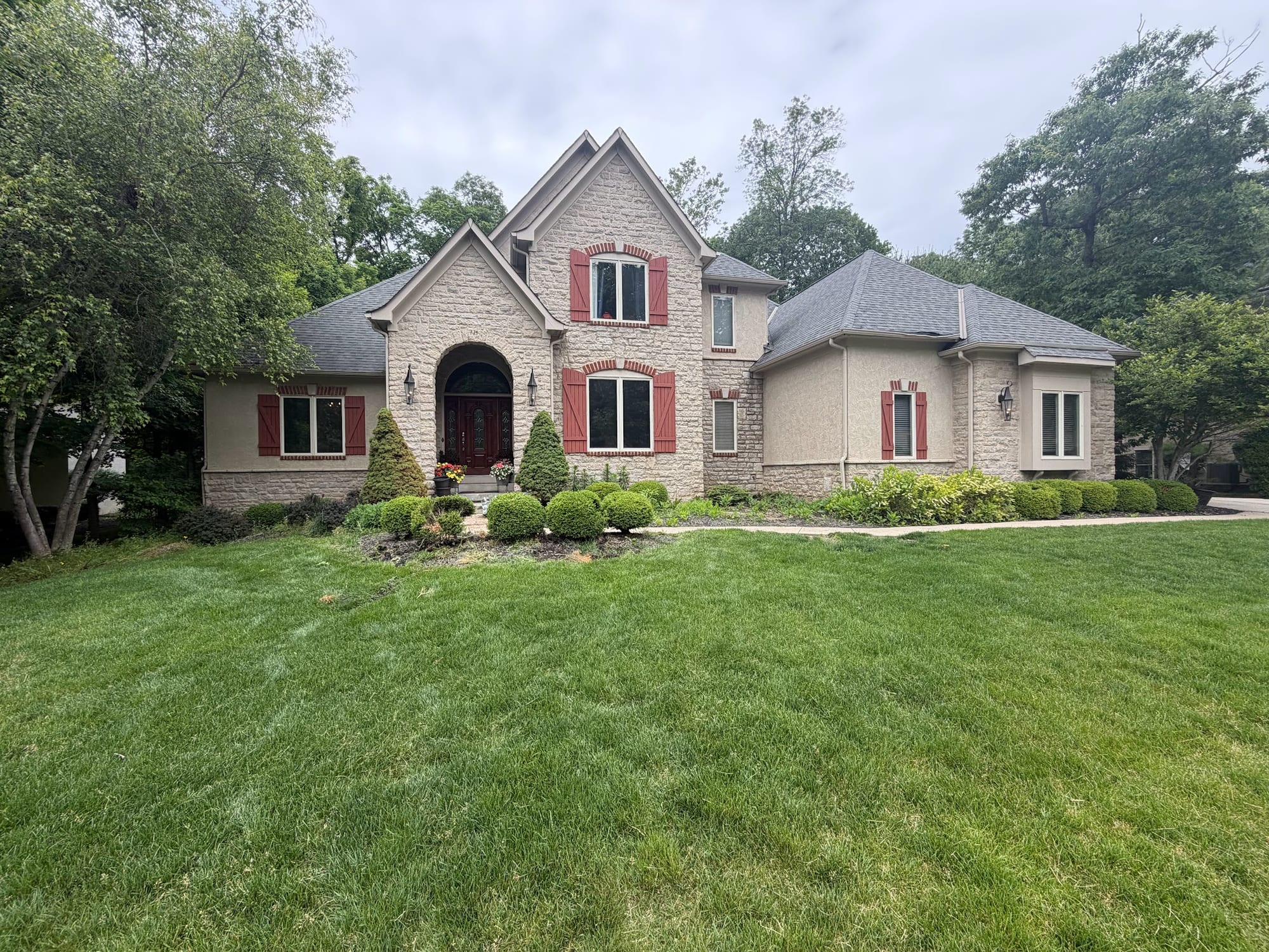 Striped front lawn at a two-story brick home
