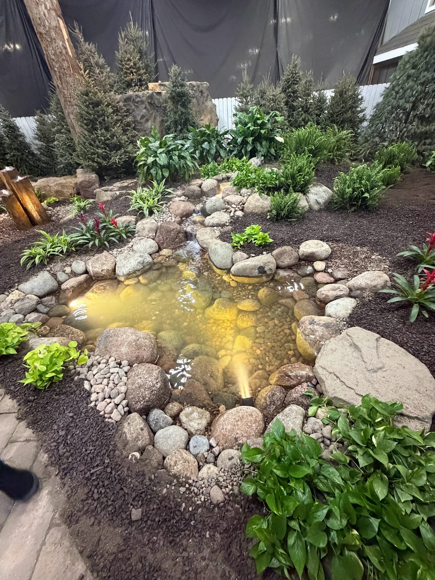 Backyard pond water feature edged in boulders