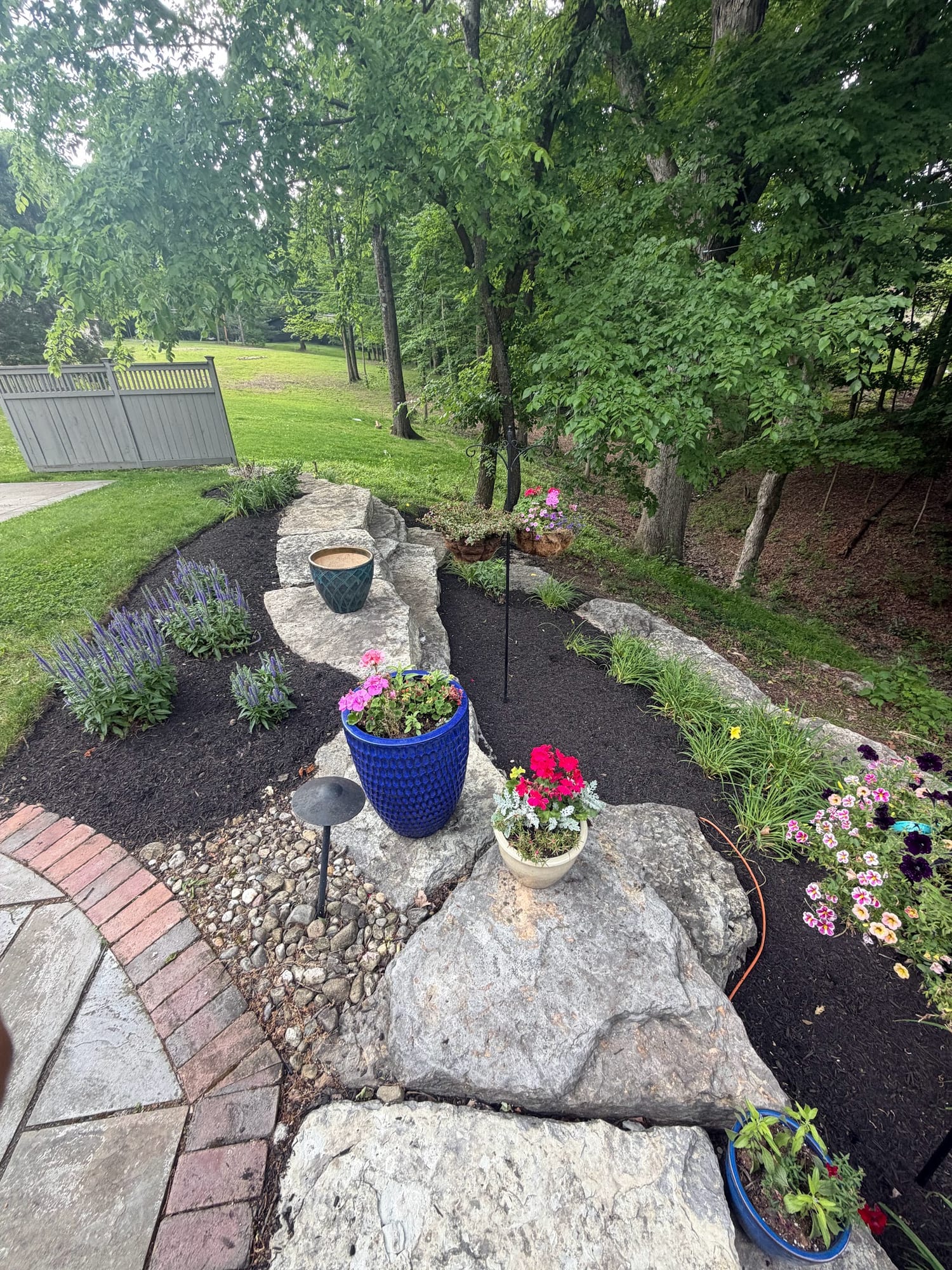 Stone garden path with boulders and seasonal flowers