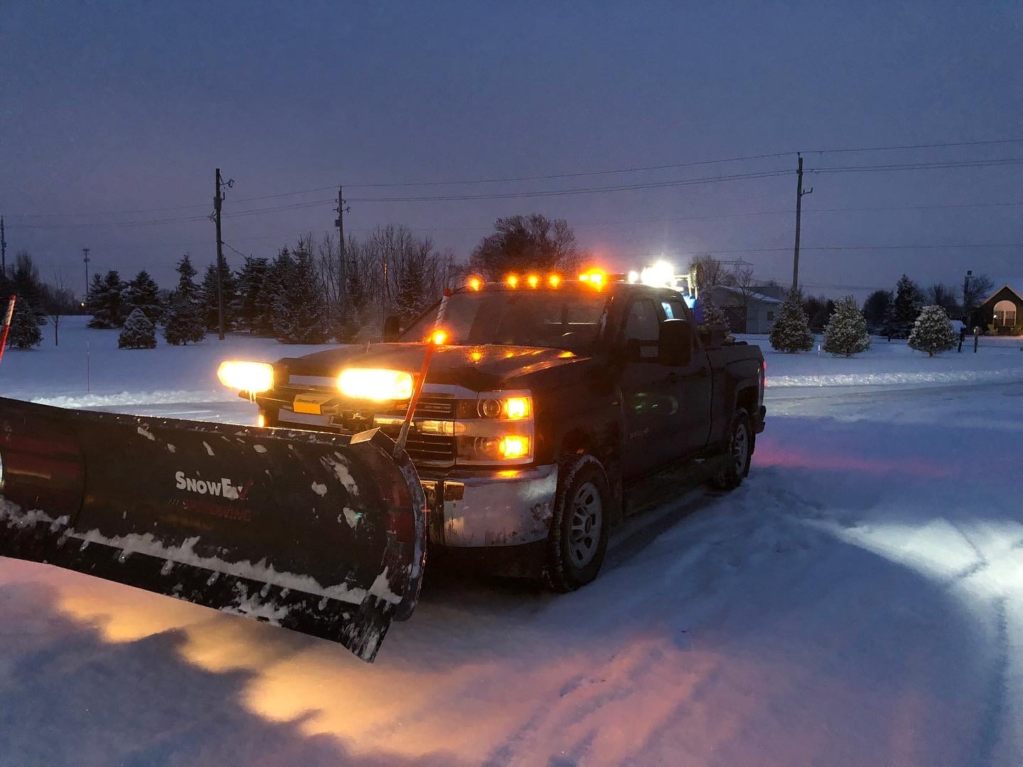 Plow truck clearing snow at night